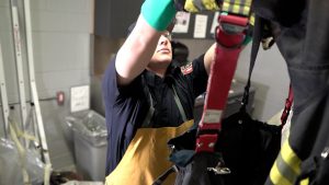 Fireman placing gear on gear dryer